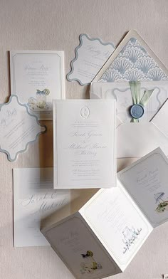 the wedding stationery is laid out on top of each other, including cards and envelopes