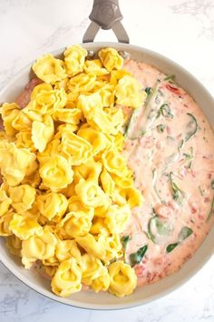 a bowl filled with macaroni and cheese on top of a white marble counter