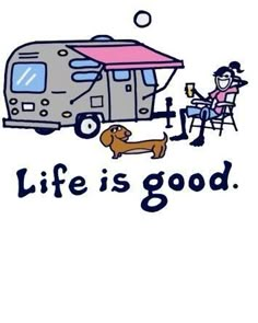 a woman sitting at a table in front of a camper with a dog next to it