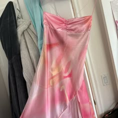 three dresses hanging on a clothes rack next to a door