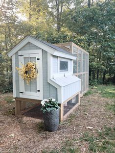 a chicken coop with a wreath on the door and window in it's side