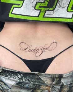 a woman's stomach with the word lucky you tattooed on her lower side ribcage