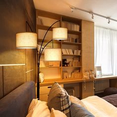 a bed room with two beds and a book shelf next to a window filled with books