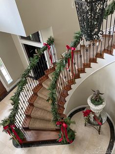 a staircase decorated for christmas with garland and bows on the bannister railings