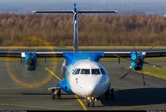 a blue and white airplane is on the runway