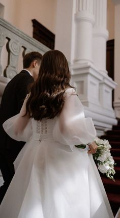 the bride and groom are walking down the stairs at their wedding ceremony in an old church