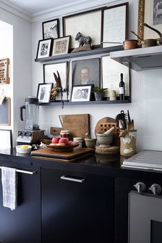 the kitchen counter is covered with pictures and other things on it's shelfs