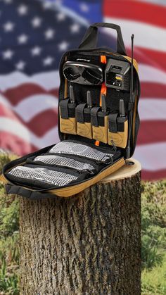 a bag sitting on top of a tree stump with an american flag in the background