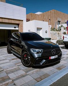 a black mercedes suv parked in front of a building