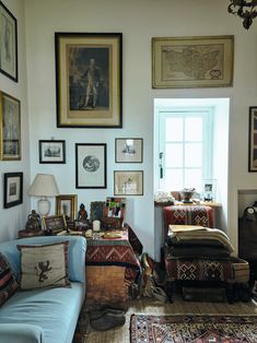 a living room filled with furniture and pictures on the wall