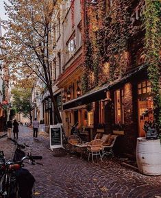 a cobblestone street with tables and chairs on it