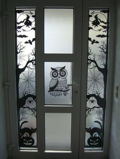 a glass door decorated with an owl and spider webs on it's side