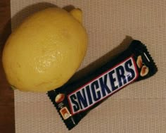 an orange and a snickkers bar on a table