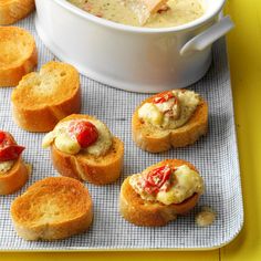 several small pieces of bread on a tray with some soup in the bowl and other appetizers