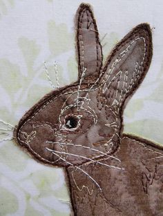 a close up of an embroidered rabbit on fabric