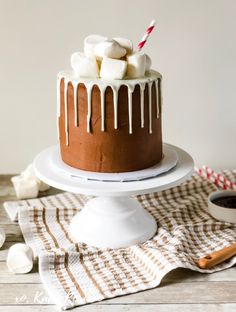 a chocolate cake with marshmallows on top and icing drizzled over it