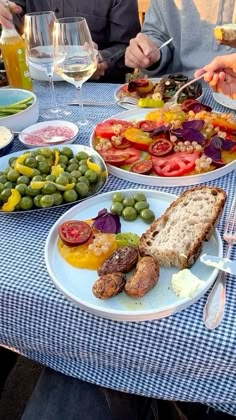 people sitting at a table with plates of food