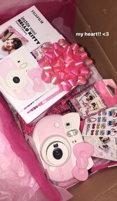 a pink camera and other items in a box