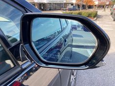 the rear view mirror is reflecting cars on the road