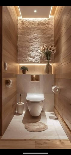 a bathroom with wood paneling and white toilet in the center, surrounded by wooden walls