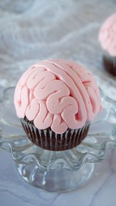 two cupcakes with pink frosting in the shape of a brain