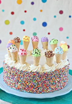 an ice cream cake with sprinkles and cones on top is decorated with multicolored confetti