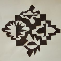 several pieces of paper cut into shapes on a white surface with black and white lines