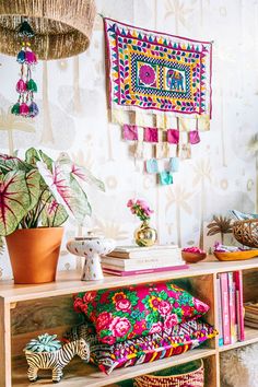 a shelf with some colorful items on top of it next to a potted plant