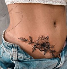 a woman's stomach with a flower tattoo on her belly and the bottom part of her lower body