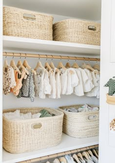 an organized closet with baskets and clothes hanging on the wall next to shelves filled with baby's clothing