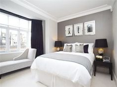 a white and gray bedroom with pictures on the wall