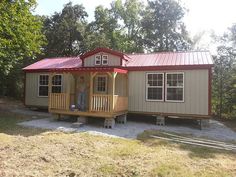 a small house with a red roof in the woods