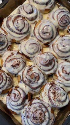 a pan filled with cinnamon rolls covered in icing