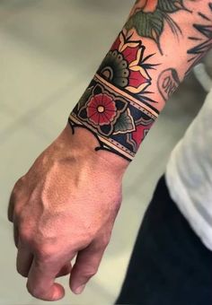 a man's arm with tattoos on it and a flower tattoo on the wrist