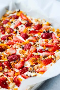 a dessert dish with strawberries and nuts on top