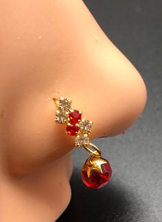 an earring with red and white stones on top of a mannequin's head