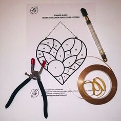 scissors, tape, pliers and other crafting supplies laid out on top of a piece of paper