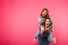 two women are holding each other in front of a pink background