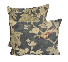 two decorative pillows with birds on them, one in grey and the other in gold