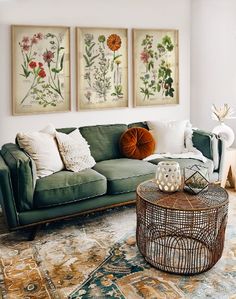 a living room filled with furniture and paintings on the wall above it's coffee table