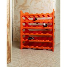 an orange wine rack in the corner of a room