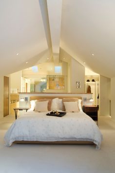 a large white bed sitting inside of a bedroom