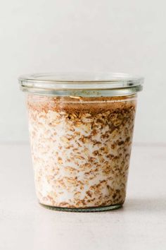 a glass jar filled with food sitting on top of a white counter next to a wall