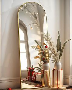 a large mirror sitting on top of a table next to a vase filled with flowers