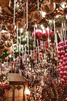 a christmas tree with ornaments hanging from it's sides and lights on the ceiling