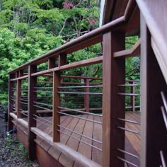 a wooden deck with railings and trees in the background