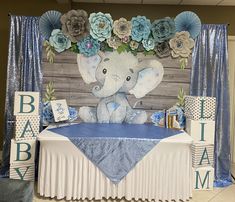 a baby shower with an elephant and flowers on it's head is displayed in front of a backdrop