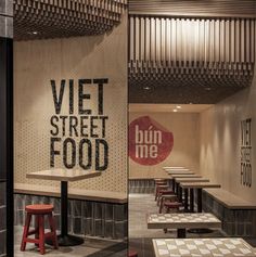 a restaurant with tables and stools in front of a sign that reads viett street food