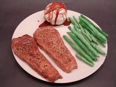 a plate with meat, asparagus and other food items on top of it