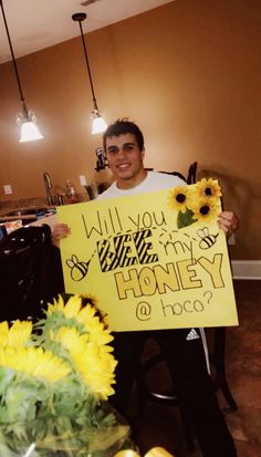 a man holding up a sign that says will you marry honey or poco?